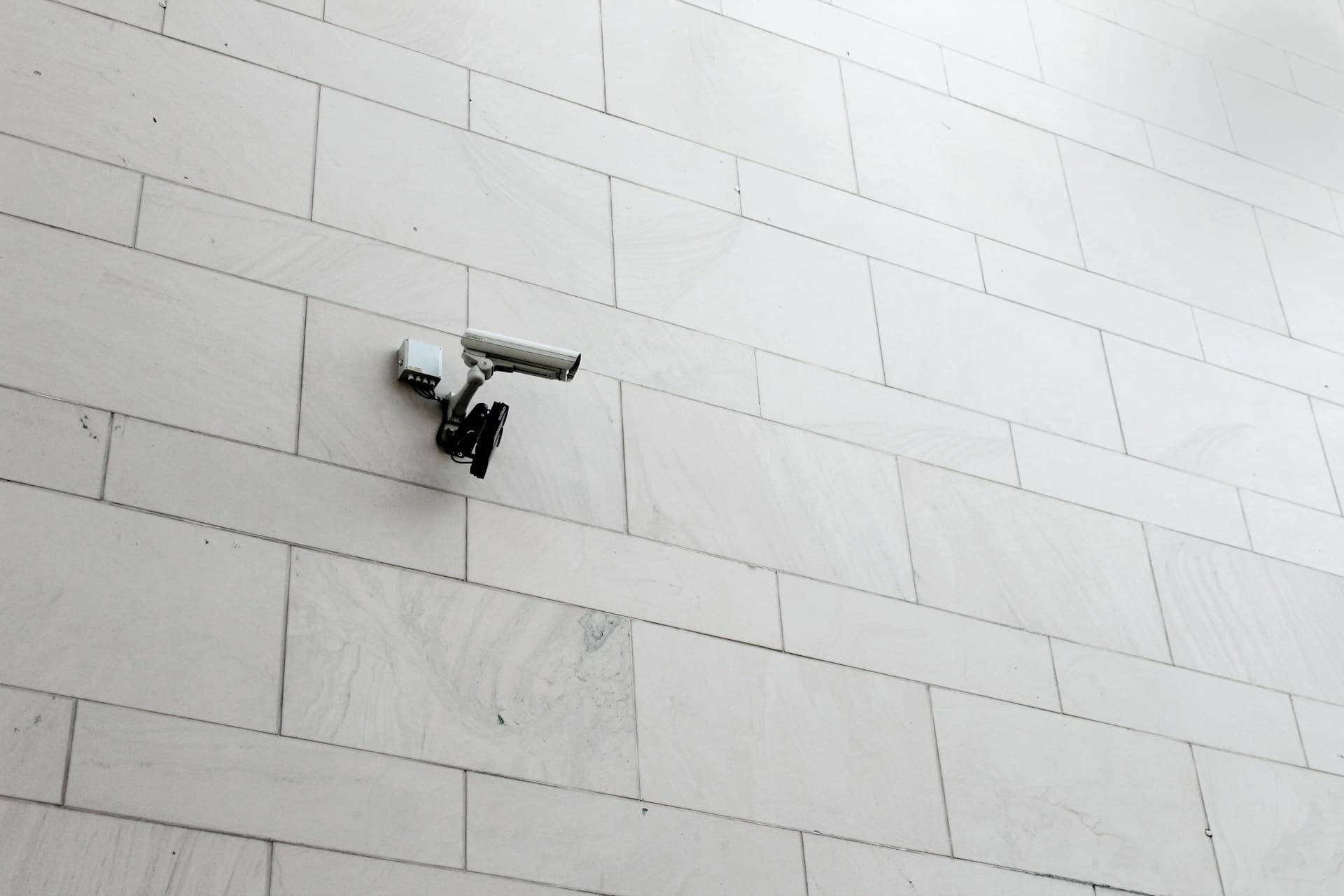 white cctv camera on a white wall